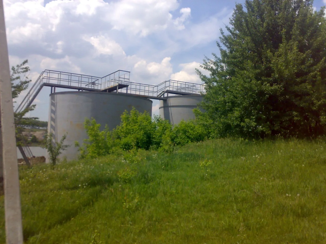 Дві реальні металеві ємності компактних очисних споруд молокозаводу на майданчику — відстійник-флотатор з аеротенками та блок доочистки